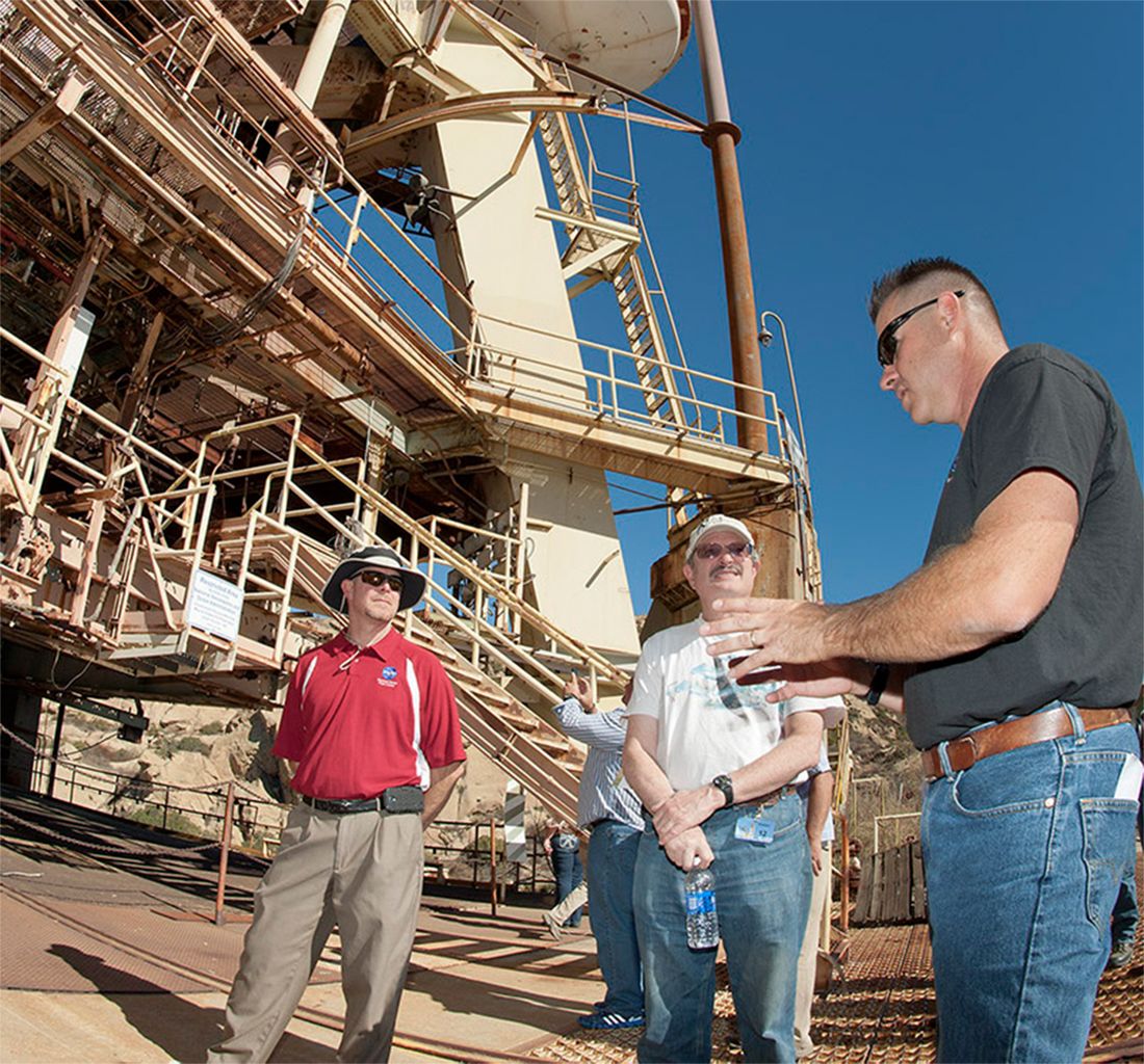Peter Zorba, NASA SSFL Project Director, talking with visitors at the base of a test stand.